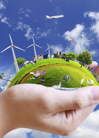 Mano che sostiene un mondo verde, energia e natura in armonia.