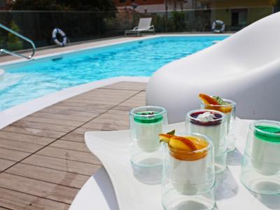 Cocktail colorati a bordo piscina, atmosfera rilassante e fresca.