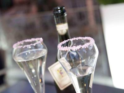Calici di champagne con bordo zuccherato rosa, atmosfera romantica.