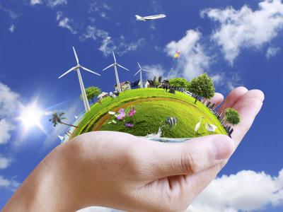 Mano che sostiene un mondo verde, energia e natura in armonia.